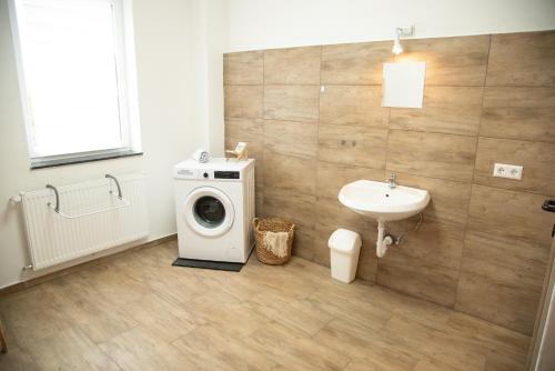a bathroom with a washing machine and a sink at geräumige Ferienwohnung mit Terrasse in Kirchberg an der Jagst