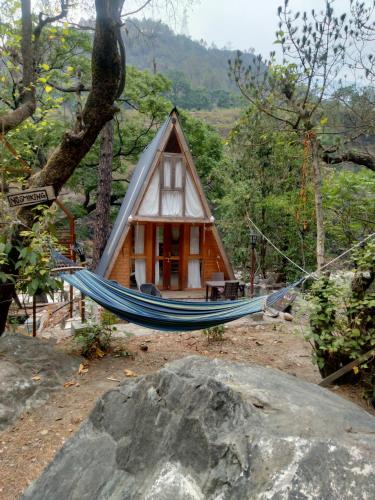 a hammock in front of a small house at Alaknanda Kinare in Chamoli