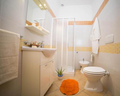 a bathroom with a toilet and a sink and a shower at La Muzza Bed & Breakfast in Zollino
