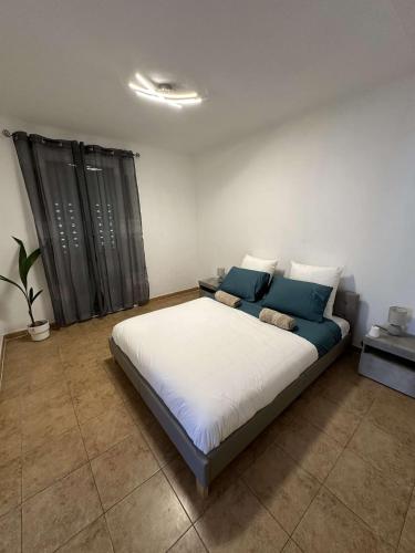 une chambre avec un grand lit avec des oreillers bleus dans l'établissement Villa - 100 m - Beach - Free Parking, à Villeneuve-Loubet