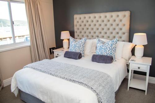 a bedroom with a large white bed with blue pillows at Waterfront- 11 South Quay in Knysna