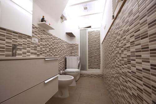 baño con aseo y paredes de ladrillo en Gaia Holiday House, en Grottaferrata