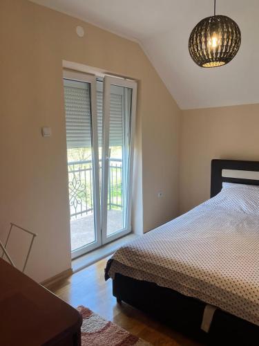 a bedroom with a bed and a large window at Anzoli 1 in Nikšić