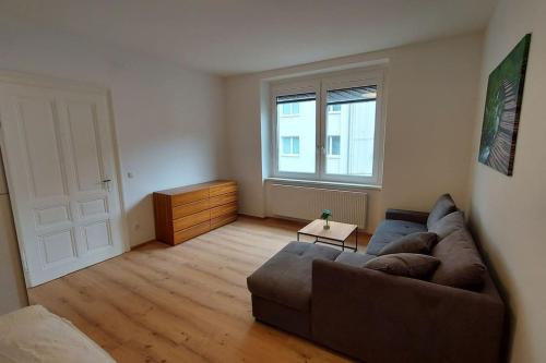 sala de estar con sofá y ventana en Appartement Top5b - Budget, en Linz