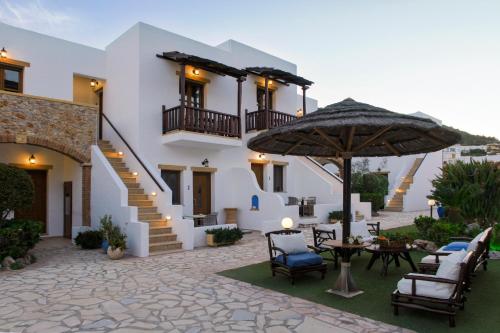 a house with a patio with chairs and an umbrella at Panteli Beach Hotel in Panteli