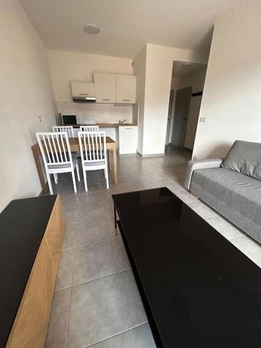 un salon avec un canapé, une table et des chaises dans l'établissement Le Saint Quentin, à Juvignac