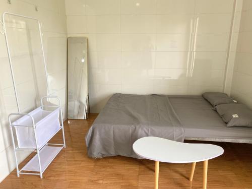 ChuLaLa Khe Sanh في Hương Hóa: غرفة صغيرة بها سرير وكرسي أبيض