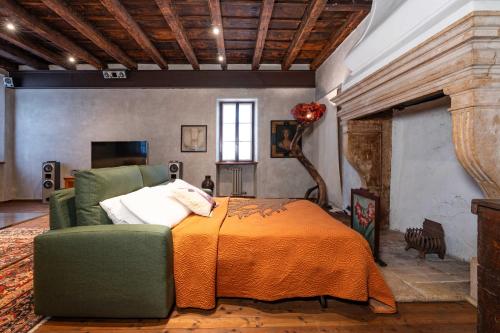 een slaapkamer met een bed en een groene stoel bij Casa dei Camini Venetian Villa in Caprino Veronese