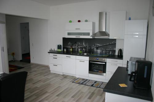 een keuken met witte kasten en een fornuis met oven bij Appartment Herten - Auch zur EM 2024 Arena AufSchalke in Herten