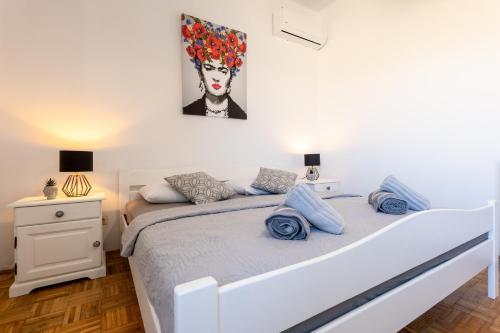a bedroom with a bed and a painting on the wall at Apartment Kosljun with pool in Košljun