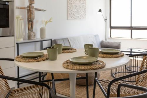 uma mesa com quatro cadeiras e uma mesa branca com pratos e tigelas em Seashore Rosamar em Armação de Pêra