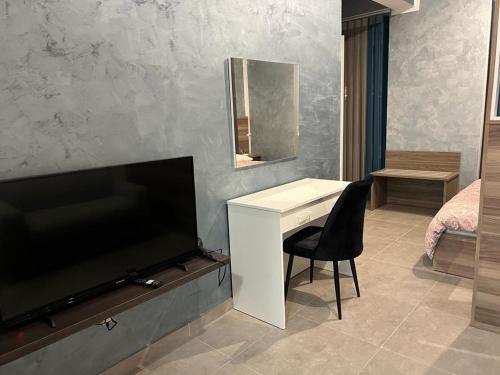 Camera con TV e scrivania con specchio. di Stresa Court Apartments a San Giuliano