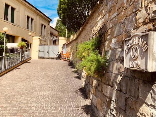 a stone wall with a sign on the side of a building at Le Residenze dei Serravallo in Trieste