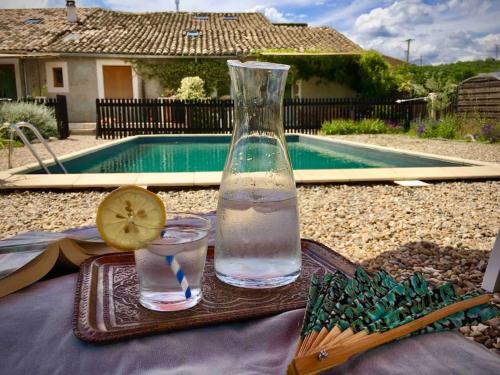 une bouteille d'eau et un verre d'eau avec un citron dans l'établissement La Petite Grange, pour un séjour écolo-chic !, à Lachapelle-sous-Aubenas
