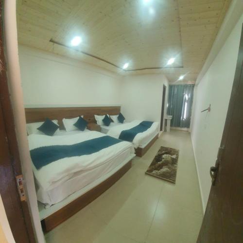 En eller flere senge i et værelse på Hotel Geeta Badrinath