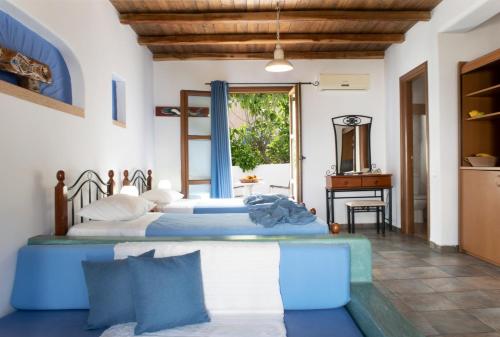 a bedroom with two beds and a table at Panteli Beach Hotel in Panteli