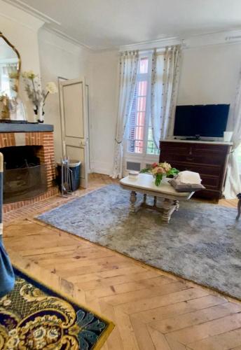 un salon avec une table et une cheminée dans l'établissement La chambre des écureuils, à Harcanville