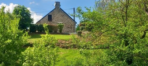 an old stone house in the middle of a yard at Gîte de Fourneaux in Pont-d'Ouilly