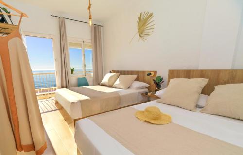 a bedroom with two beds with a view of the ocean at Maxcaly Playa in Águilas