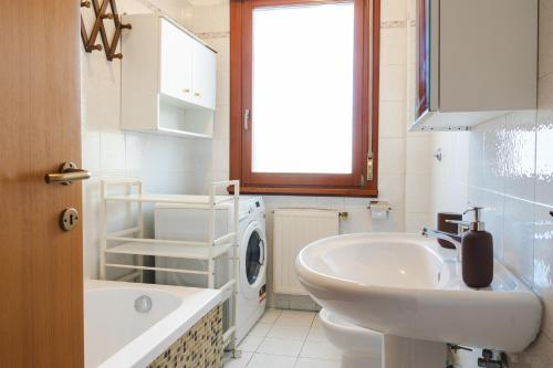 łazienka z umywalką i pralką w obiekcie Alessandrino Apartment w Rzymie