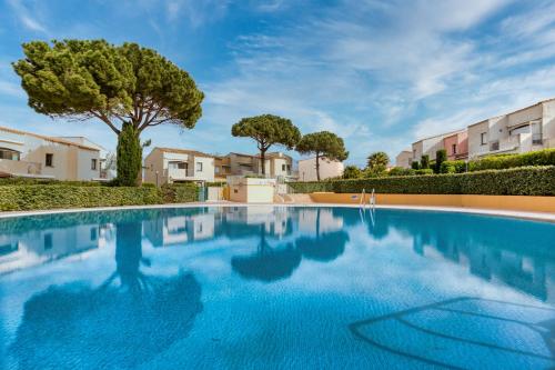 - une piscine dans une villa avec des arbres et des bâtiments dans l'établissement Appartement Plain Pied Cap, au Cap d'Agde