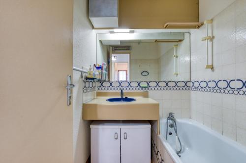 une salle de bain avec un lavabo, une baignoire et un miroir dans l'établissement Appartement Plain Pied Cap, au Cap d'Agde