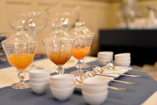 ブラガにあるHotel Villa Garden Bragaのオレンジが入ったワイングラスが2つ置かれたテーブル