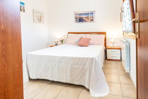 カポリーヴェリにあるAppartamenti Le Querce App. Ficoのベッドルーム1室(白い掛け布団付きのベッド1台付)