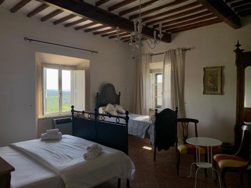 1 dormitorio con 2 camas, mesa y ventana en Casa Cerboneschi en Casale Marittimo