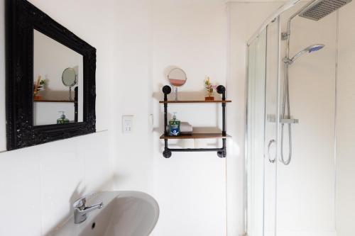 een badkamer met een wastafel en een spiegel bij Warm&Welcoming City Centre Apartments by Meadows 11 in Edinburgh