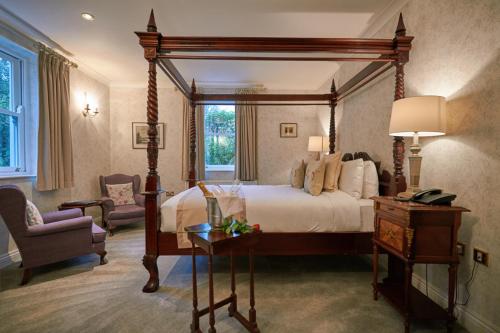 a bedroom with a large canopy bed and a chair at Seaview House Hotel in Bantry