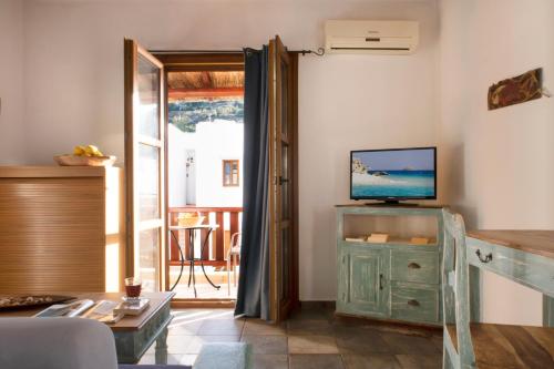 a living room with a tv on top of a dresser at Panteli Beach Hotel in Panteli