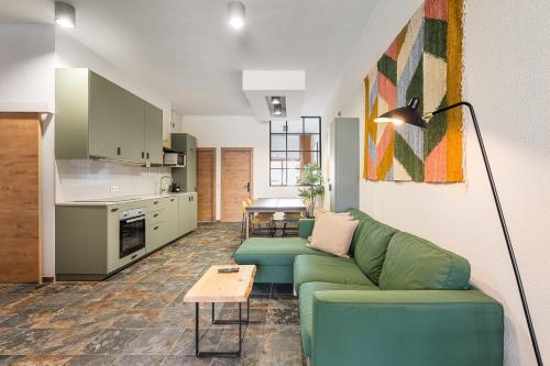 a living room with a green couch and a table at GuestReady - Modern Home In Gaia in Vila Nova de Gaia