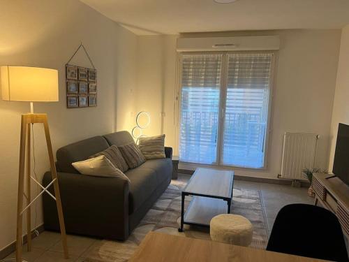 un salon avec un canapé et une table dans l'établissement La Canée, à Juvignac