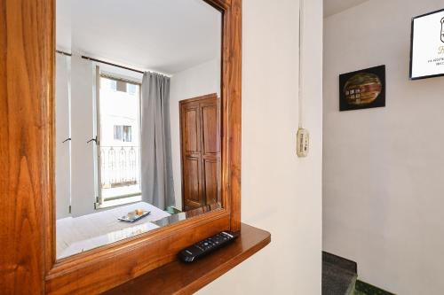 ein Spiegel, der auf einer Theke neben einem Fenster sitzt in der Unterkunft Albergo Della Posta in Bracciano