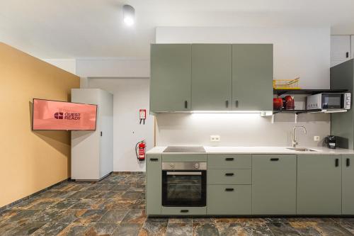 a kitchen with white cabinets and a stove at GuestReady - Modern Home In Gaia in Vila Nova de Gaia