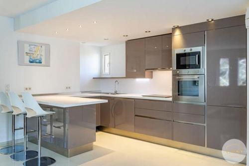 een keuken met roestvrijstalen apparatuur en witte muren bij APPART Tropez 1 in Saint-Tropez