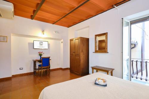 a room with a bed and a table and a chair at Albergo Della Posta in Bracciano