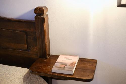 a book sitting on a table next to a bed at Albergo Della Posta in Bracciano