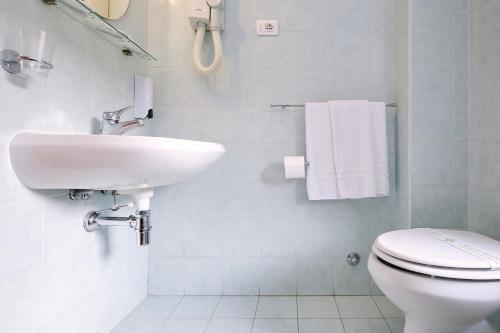 a white bathroom with a sink and a toilet at Albergo Della Posta in Bracciano