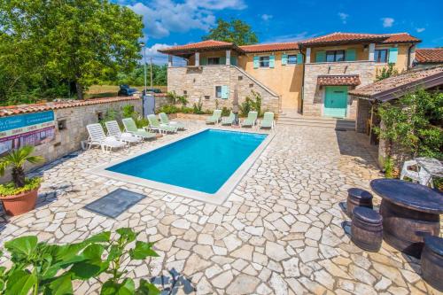 a backyard with a swimming pool and a house at Villa Sandi, mediterranean Villa with pool and jacuzzi in Gračišće