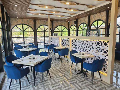 una sala da pranzo con tavoli e sedie blu di Hotel The Bundela - Khajuraho, Madhya Pradesh a Khajurāho