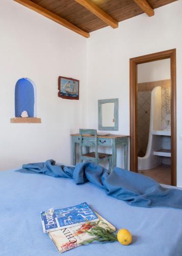 a bedroom with a blue bed with a book on it at Panteli Beach Hotel in Panteli