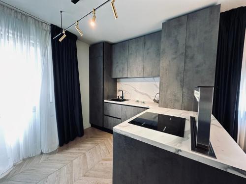 a kitchen with a counter and a sink and a window at Shades of Cluj Napoca in Cluj-Napoca