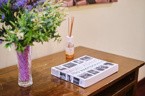 a book sitting on a table next to a vase of flowers at Albergo Della Posta in Bracciano