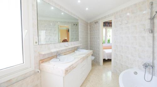 a white bathroom with two sinks and a mirror at Bellavista MM in Denia