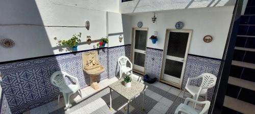 Elle comprend un balcon doté de carrelage bleu et blanc ainsi que de chaises blanches. dans l'établissement Casa típica Andaluza El Lucero, à Rute