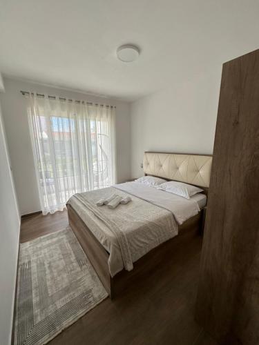 a bedroom with a bed and a large window at Apartments Amar in Ulcinj
