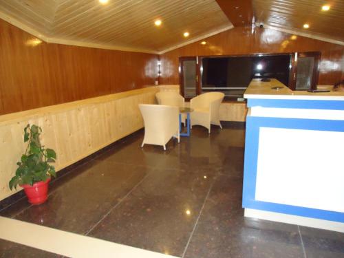 a kitchen with a table and white chairs in a room at Wonder Hill Kasauli in Kasauli