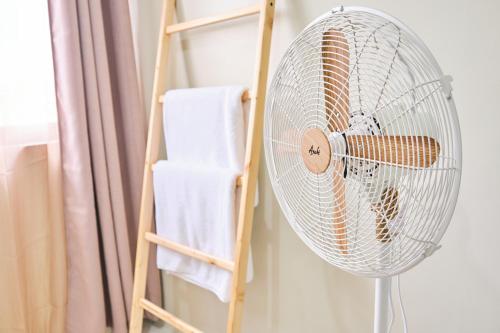 a white fan in a room next to a towel rack at QFandZ Baguio Homestay at BRENTHILL Condominium in Baguio